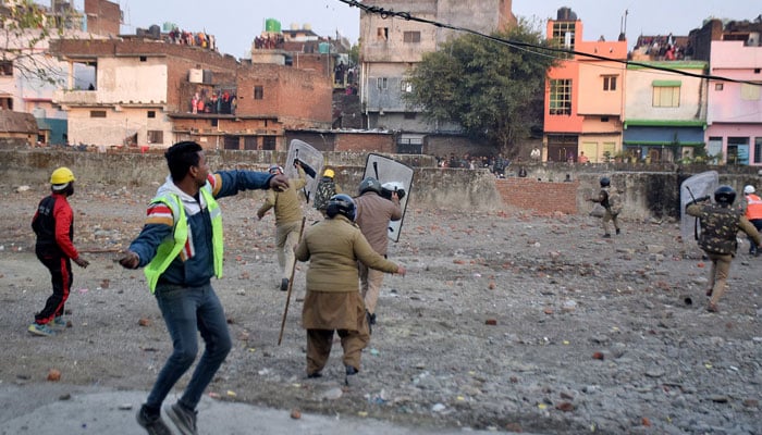 Police officers throw stones towards the demonstrators during a protest against a government demolition drive, in Haldwani in the northern state of Uttarakhand, India on February 8, 2024. — Reuters