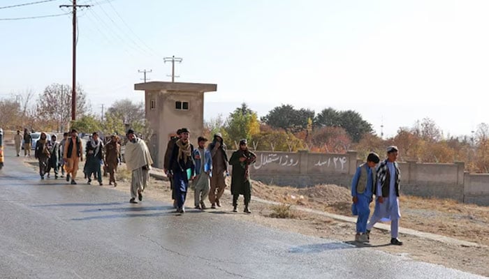 Afghans walk towards a football stadium ahead of the public execution of a man, by the Taliban at Gardez in Paktia province on November 13, 2024. — AFP