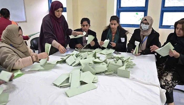 Polling officials count votes at a polling station. — APP/File