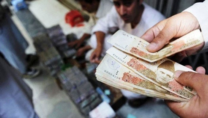 A man counting five thousand notes. — AFP/File