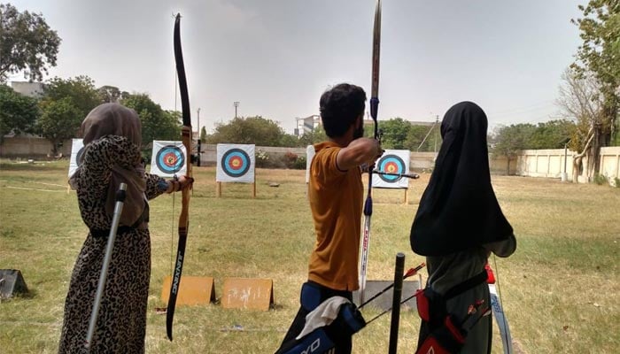 An undated image shows three archers taking aim at their targets during an archery camp at Karachi University, Karachi. — Facebook/QAA Archery