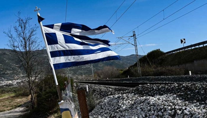 Greece flag near a railway track. — AFP/File