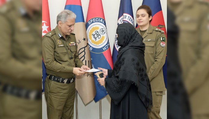 Inspector General of Police (IGP) Punjab Dr Usman Anwar distributes cheque to a family of martyr on November 15, 2024. — Facebook@PunjabPolicePakistanOfficial