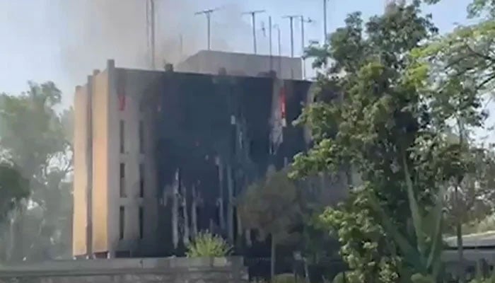 Smoke rises after alleged PTI protesters torched the Radio Pakistan building in Peshawar on May 9, 2023. —  Screengrab via YouTube/Geo News