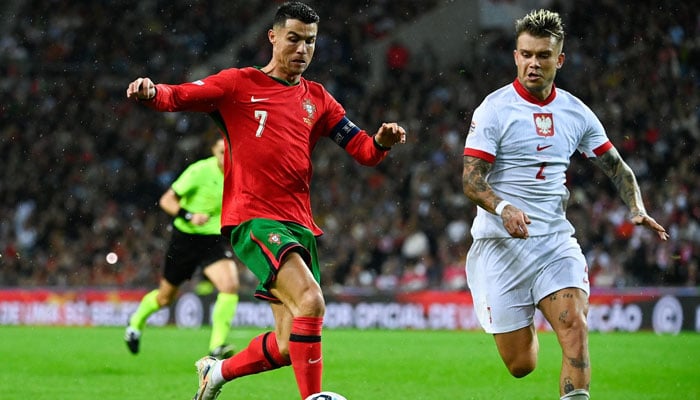 Portugals forward Cristiano Ronaldo (left) fights for the ball with Polands defender Kamil Piatkowski during the UEFA Nations League, League A, Group 1 football match between Portugal and Poland at the Dragao stadium in Porto, on November 15, 2024. — AFP