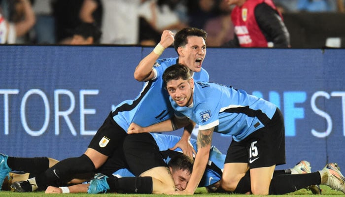 Uruguays midfielder Manuel Ugarte (bottom) celebrates with teammates after scoring his teams winner in their 3-2 victory over Colombia on November 15, 2024. — AFP