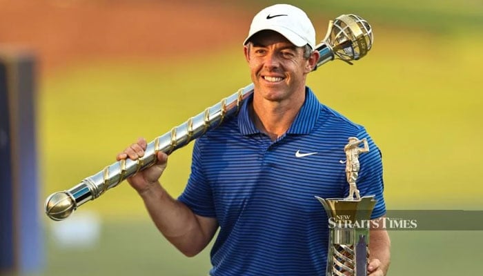 Northern Irelands Rory McIlroy gestures as he poses for a picture with the trophy after winning the DP World Tour Championship at Jumeirah Golf Estates in Dubai on Sunday. — AFP/file