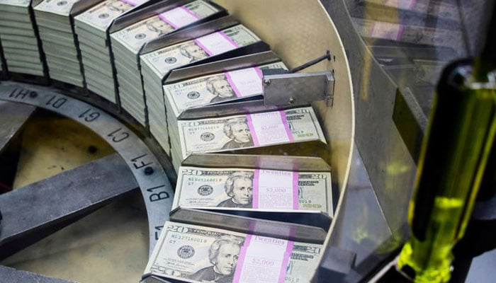 Bundles of freshly printed US dollar banknotes are processed for packaging at the US Treasurys Bureau of Engraving and Printing in Washington on July 20, 2018. — AFP