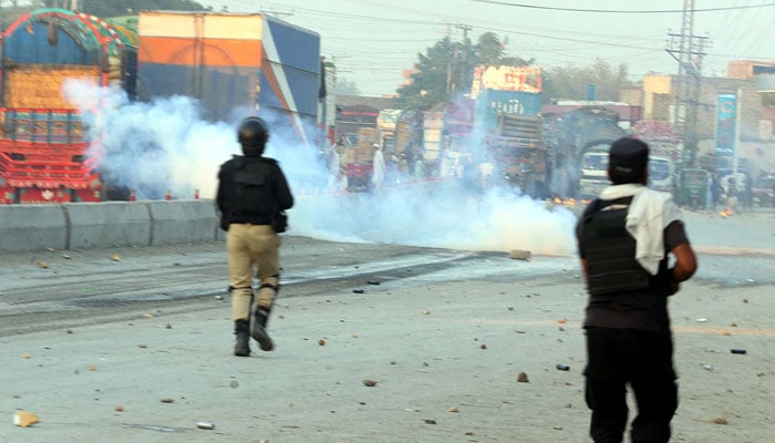 Police officials baton charge and fire tear gas to repel angry mob while protesting over blasphemy allegations, at Charsadda road in Peshawar on November 19, 2024. — PPI