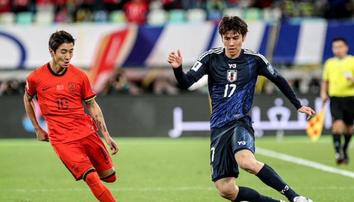 Chinas Wei Shihao (left) fights for the ball with Japans Ao Tanaka. — AFP/file