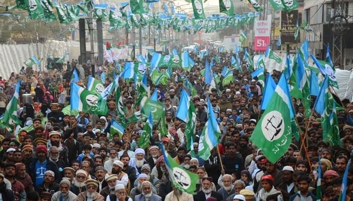 Supporters of the Jamaat-e-Islami protest holding flags at a rally in Karachi. — Online/File