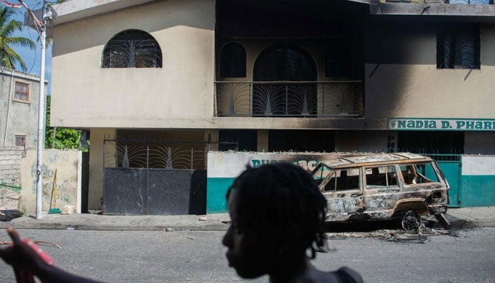 A woman looks at a damaged business in the Solino district of Port-au-Prince on November 16, 2024. — AFP