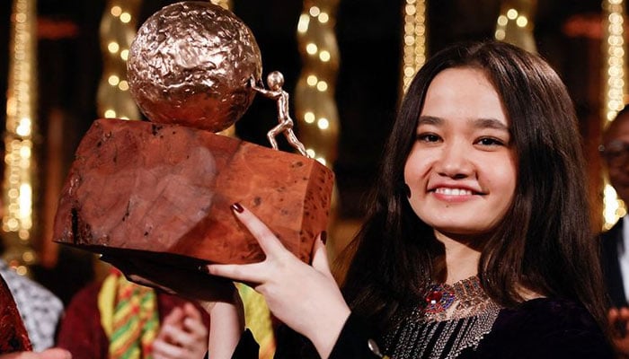 Nila Ibrahimi, a 17-year-old Afghanistan-native girls right activist, holds her prize after winning the KidsRights International Childrens Peace Prize during a ceremony at De Nieuwe Kerk, in Amsterdam, on November 19, 2024. — AFP