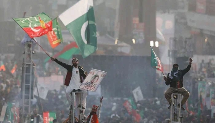 Supporters of Imran Khan sit on scaffoldings in Rawalpindi, on November 26, 2022. — Reuters