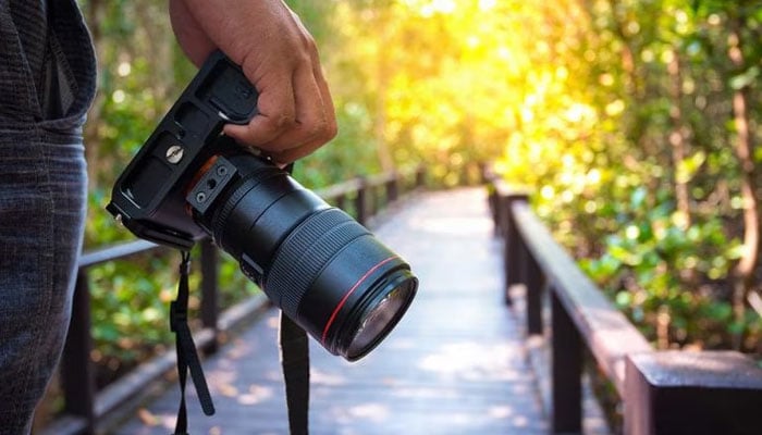 This representational image shows a person holding a camera. — britishcouncil.pk/file