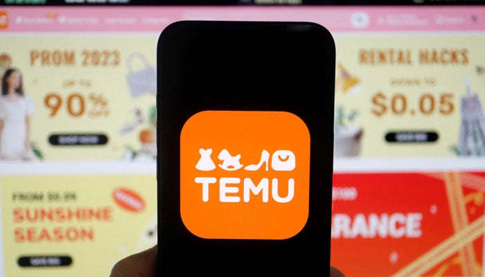 The logo of Temu, an e-commerce platform owned by PDD Holdings, is seen on a mobile phone displayed in front of its website, in this illustration picture taken April 26, 2023. — Reuters