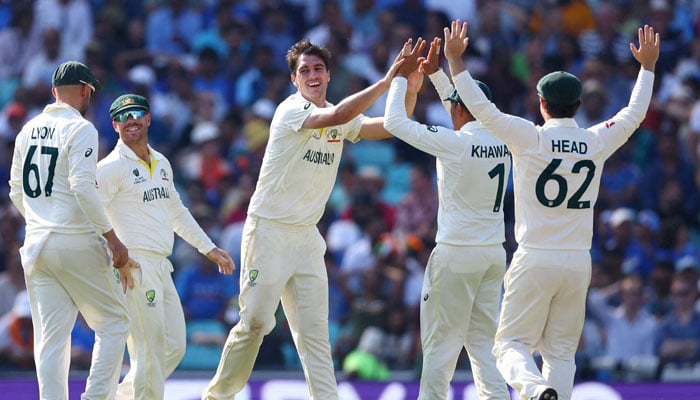 Australias Pat Cummins (centre) celebrates with teammates after taking the wicket of Indias Cheteshwar Pujara. — Reuters/file