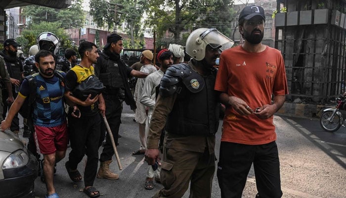 Police personnel detain supporters the Pakistan Tehreek-e-Insaf (PTI) during a protest in Lahore on October 5, 2024. — AFP