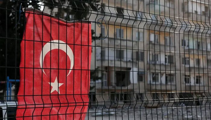 A Turkish flag is displayed on the premises of a school as damages are seen nearby, ahead of the May 14 presidential election, in the quake-hit region in Antakya, Hatay province, Turkey, May 13, 2023. — Reuters