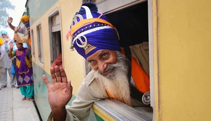 A Sikh pilgrim waves upon arrival at Wagah Railway Station. — Online/File