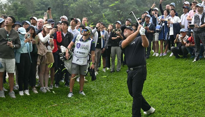 Patrick Reed hits a shot out of the rough at the Hong Kong Open. — AFP