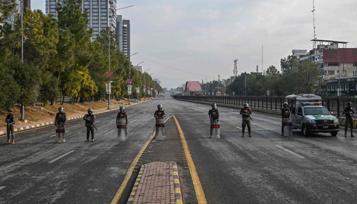 Paramilitary soldiers stand guard at a blocked road leading towards the Red Zone area ahead of a protest rally by jailed former prime minister Imran Khans PTI party in Islamabad on November 24, 2024. — AFP