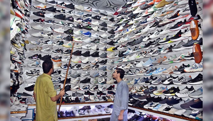 A vendor displaying shoes to attract customers in his shop on November 14, 2024. — APP