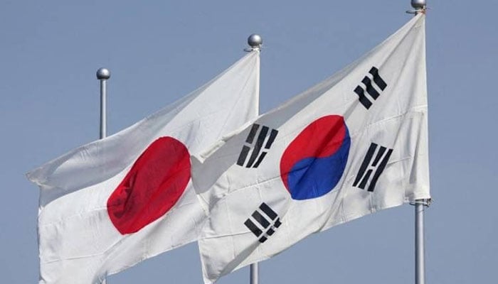 The national flags of Japan (left) and South Korea  flutter in the wind ahead of the arrival of South Korea’s President Yoon Suk Yeol at Tokyos Haneda Airport on March 16, 2023. — AFP/File