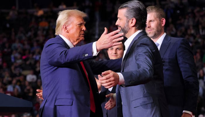 President-elect Donald Trump approaches to embrace Donald Trump Jr at his campaign rally, at PPG Paints Arena in Pittsburgh, Pennsylvania, US on November 4, 2024. — Reuters