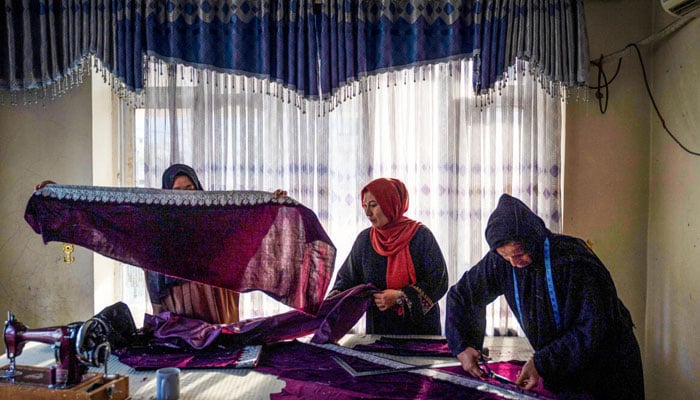 Afghan women working in their stitching room workstation. — AFP/file