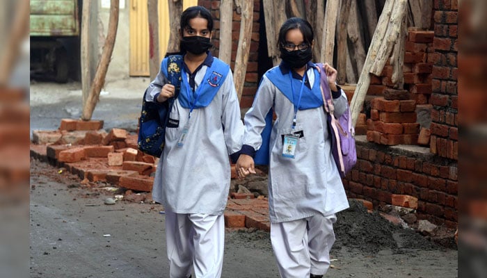 Two students going back to home after attend their class at a school in Punjab on November 20, 2024. — APP