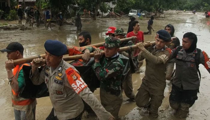 A rescue team carry a victims body following flash flooding in Radda village in North Luwu district. — AFP/File