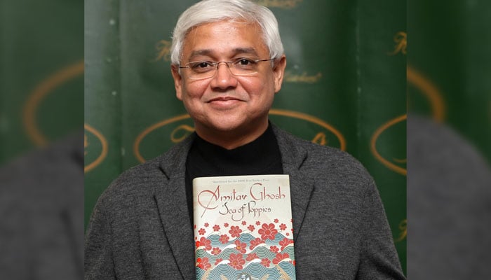 Indian author Amitav Ghosh posing with his book for a photo. — AFP/File