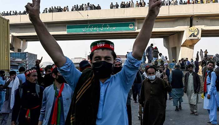 PTI supporters march towards Islamabad after clearing shipping containers placed by authorities during a demonstration on November 25, 2024. — AFP