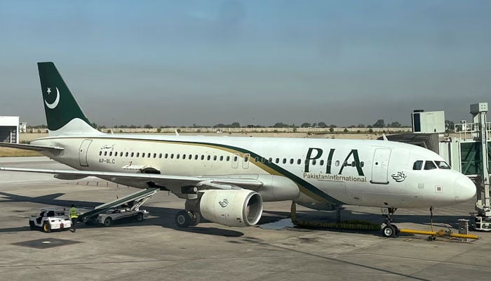 View of a Pakistan International Airlines (PIA) passenger plane, taken through a glass panel, at Islamabad International Airport, Pakistan on October 3, 2023. — Reuters