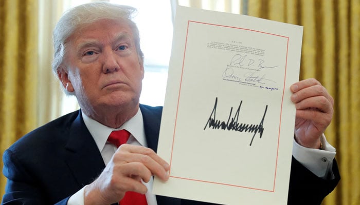 Donald Trump displays his signature after signing the $1.5 trillion tax overhaul plan in the Oval Office of the White House in Washington, US on December 22, 2017. — Reuters