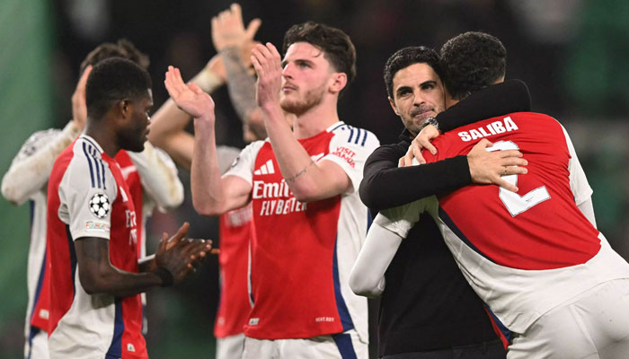 Arsenals Spanish coach Mikel Arteta (2 right) hugs Arsenals French defender William Saliba at the end of the UEFA Champions League, league phase day 5 football match between Sporting CP and Arsenal FC. —AFP/File