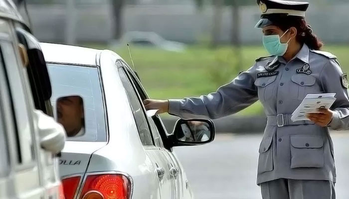 A representational showing a traffic police personnel interacting with a commuter. — APP/File