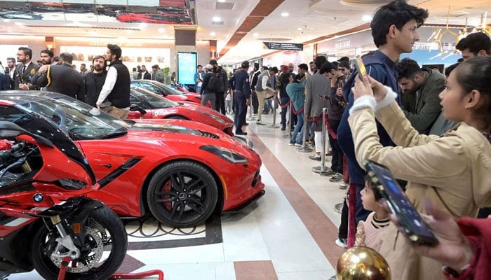 This representational image shows a girl taking picture of cars at an auto show on February 17, 2024. — APP