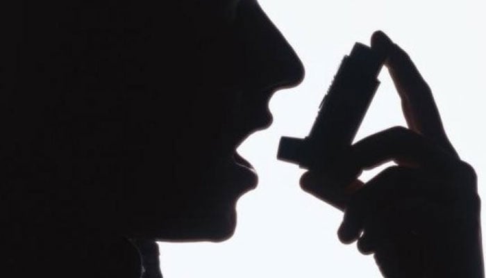 This representational image shows a patient using an asthma pump. — AFP/File