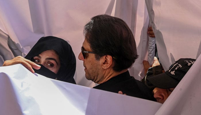 Former Pakistan Prime Minister Imran Khan (centre) with his wife Bushra Bibi (left) arrive to appear at a high court in Lahore on May 15, 2023. — AFP