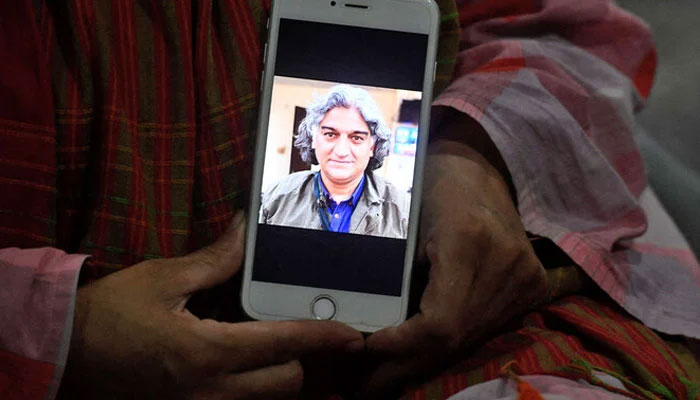 A display of Matiullah Jans photograph on a mobile phone in Islamabad on July 21, 2020. — AFP