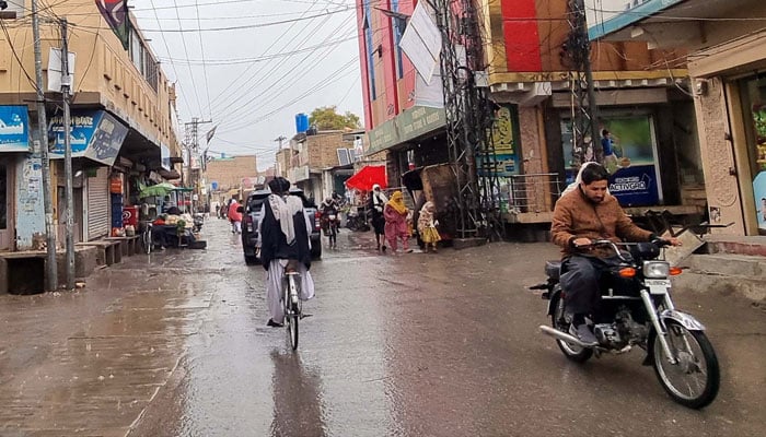 Commuters pass through a road during the downpour of winter season, in Quetta on November 29, 2024. — PPI