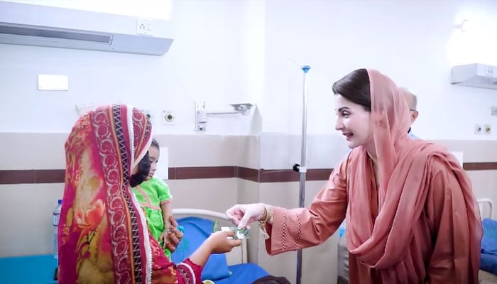 CM Punjab Maryam Nawaz handing over a health card to a woman.— Facebook@TheMaryamNSharif/File