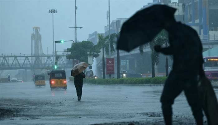 People commute along a street amid heavy rains ahead of a cyclonic storm in Chennai, India, November 30, 2024. — AFP