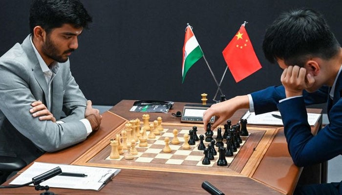 Chinas chess grandmaster Ding Liren (right) and Indias chess grandmaster Gukesh Dommaraju compete during the start of the FIDE World Chess Championship in Singapore on November 25, 2024. — AFP