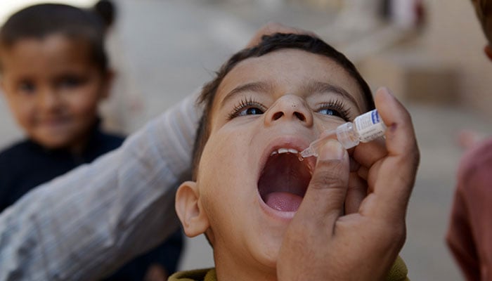 A polio worker administering a polio vaccine to a child in this undated image.— AFP/File