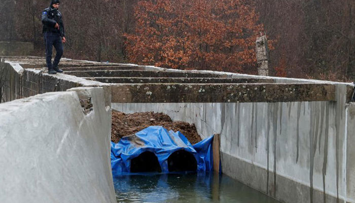 A police officer patrols near the damaged canal in northern Kosovo supplying water to two coal-fired power plants that generate nearly all of the countrys electricity,in Varage, near Zubin Potok, Kosovo November 30, 2024.— Reuters