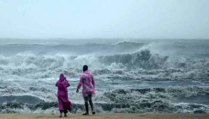 People observe waves amidst heavy winds and rainfall at Marina Beach on Nov 30, 2024, ahead of the landfall of Cyclone Fengal.— AFP