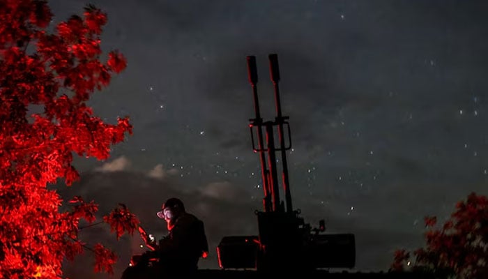 A Ukrainian serviceman from an anti-drone mobile air defence unit uses his mobile device near a ZU-23-2 anti aircraft cannon as he waits for Russian kamikaze drones, amid Russias attack on Ukraine, in Kherson region, Ukraine June 11, 2024. — Reuters